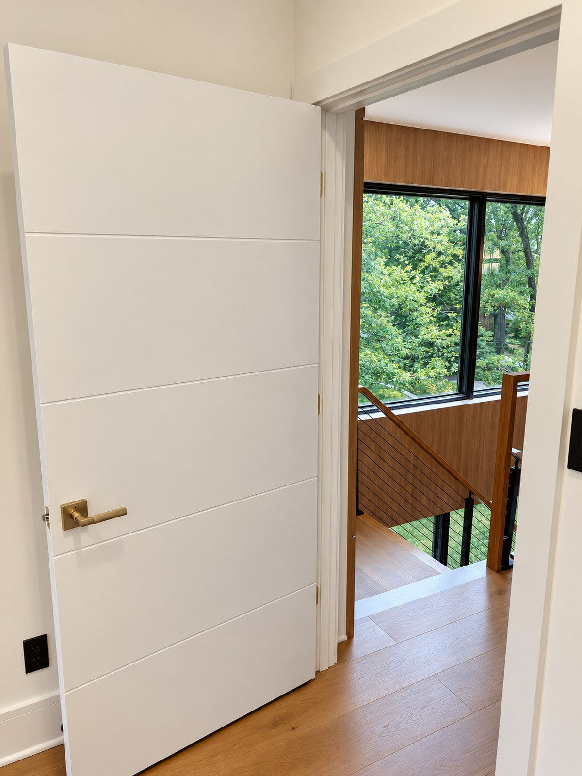 Flush interior door and oak stair-hall detail showing finish and circulation coordination